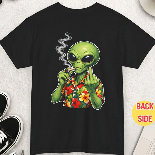 Black t-shirt with a green alien smoking a joint on a light gray surface with accessories.