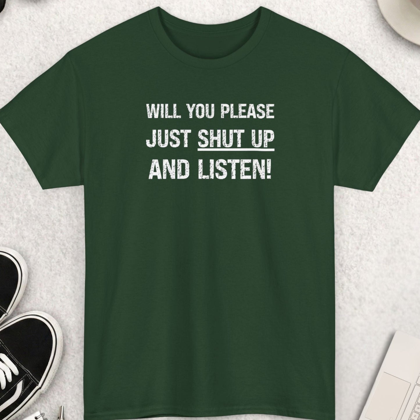 Green t-shirt with text on a light gray surface with accessories around