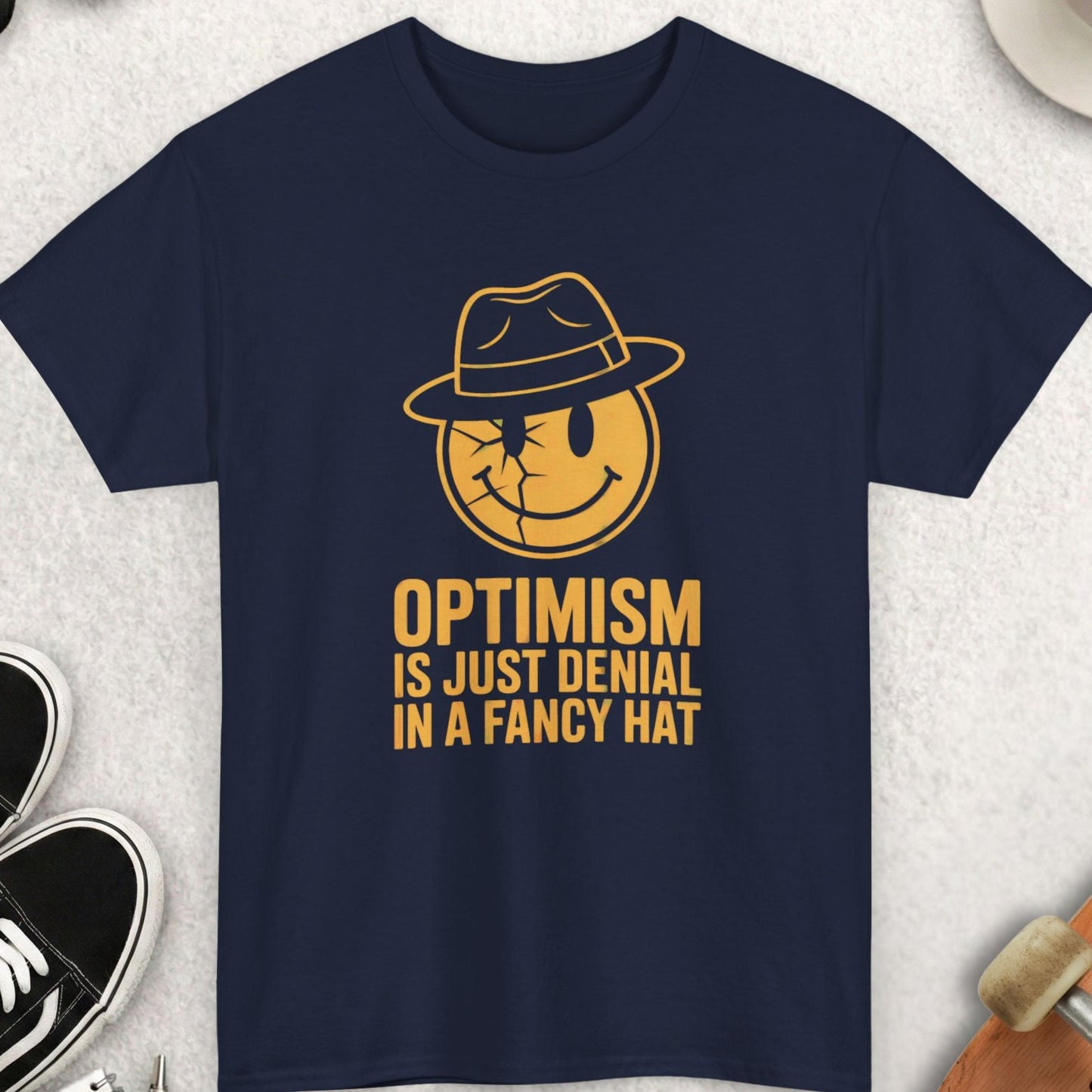 Navy blue t-shirt with yellow graphic and text on a light gray surface with accessories.