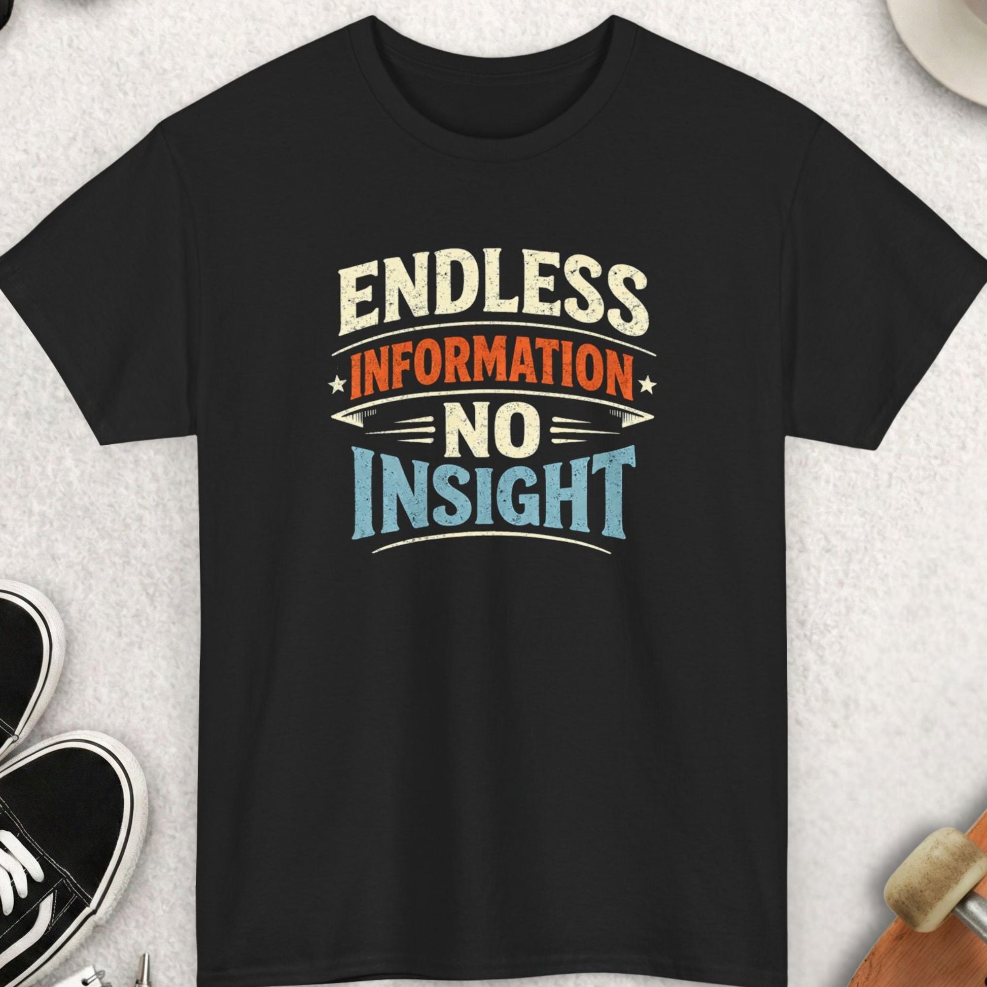 Black t-shirt with 'Endless Information No Insight' text on a light gray surface with accessories.