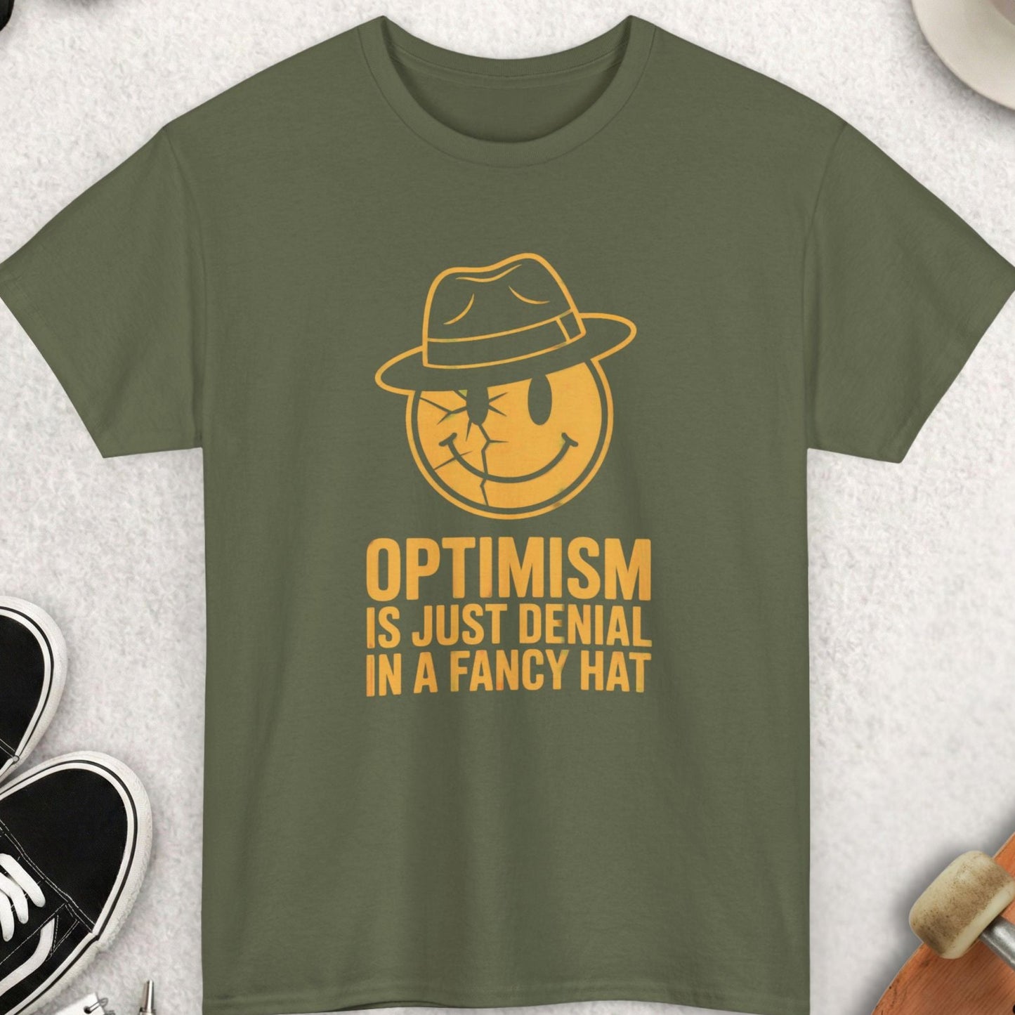 Green t-shirt with yellow graphic and text on a light gray surface with accessories.