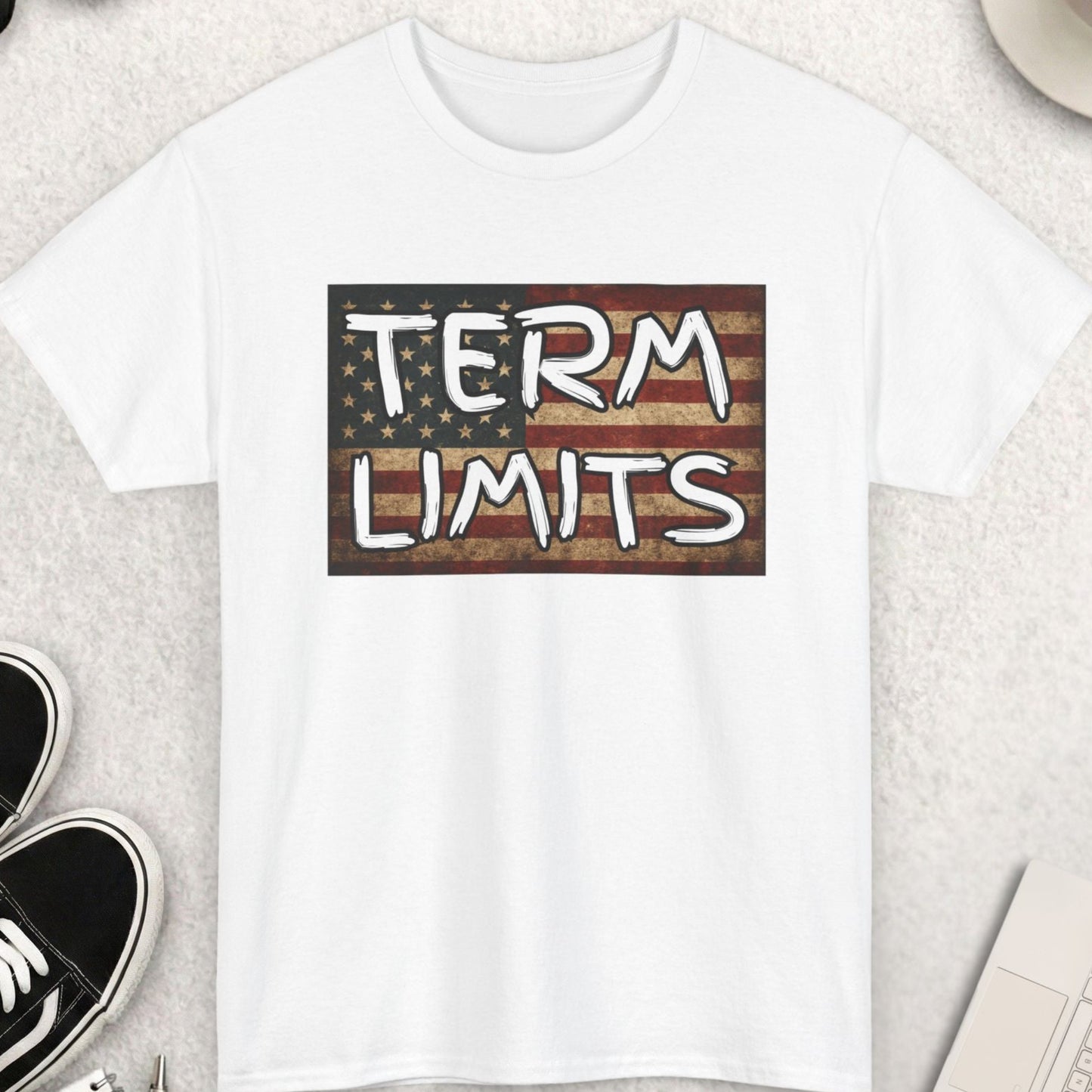 White t-shirt with 'TERM LIMITS' design on a desk with accessories.