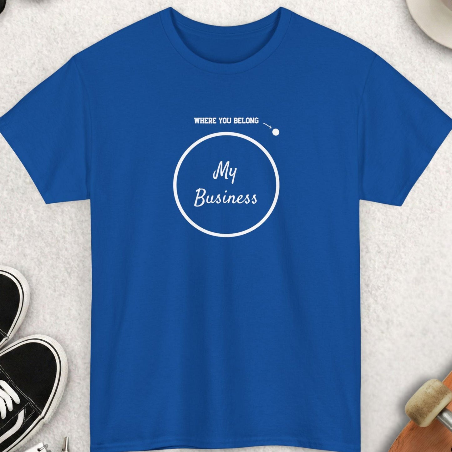 Blue t-shirt with 'My Business' design on a textured surface with accessories.