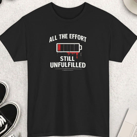 Green t-shirt with 'all the effort still no unfulfilled' text on a light gray surface with accessories.
