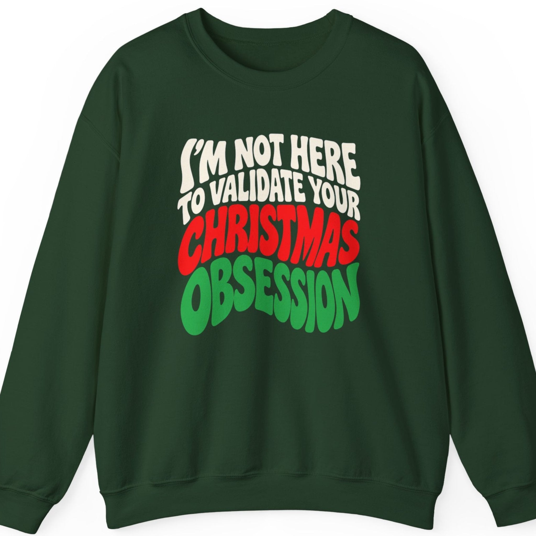 Mayhem Haus “I'm Not Here to Validate Your Christmas Obsession” forest green crewneck sweatshirt featuring bold, stacked retro typography in cream white, bright red, and green. The graphic-free design uses chunky, slightly warped lettering to deliver a sarcastic anti-Christmas message.