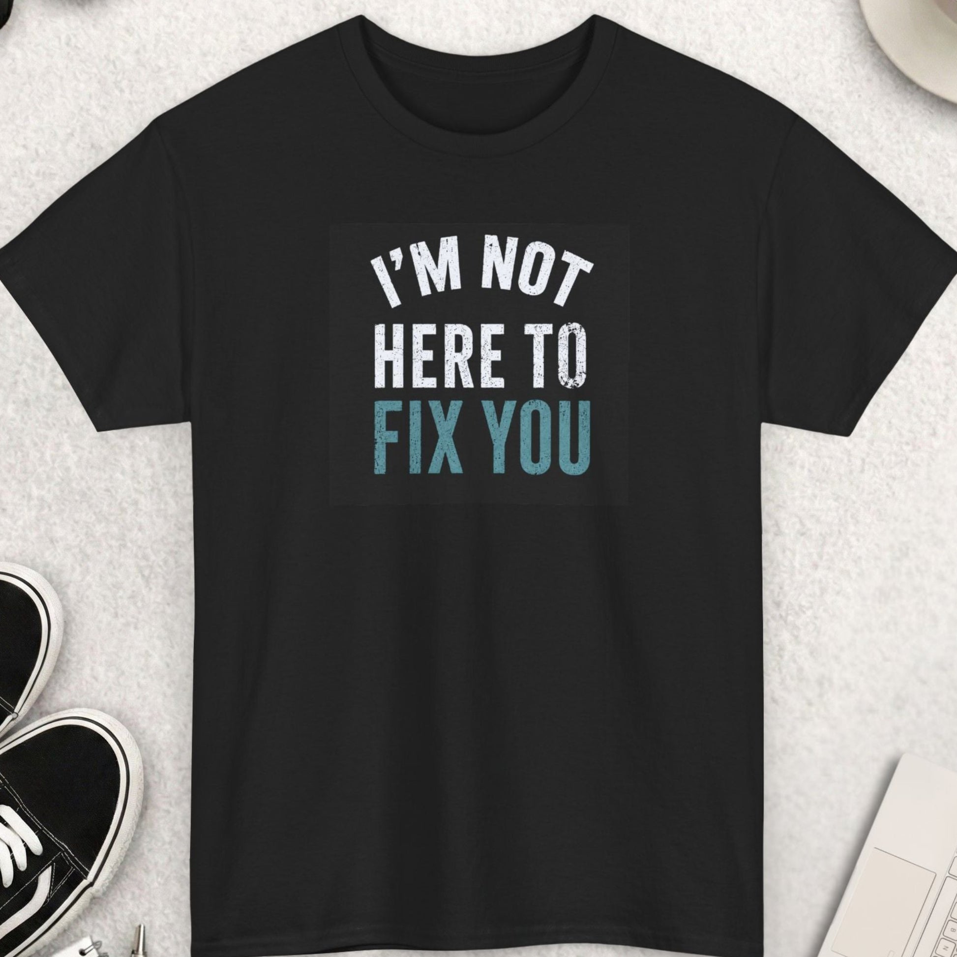 Distressed typography t-shirt featuring the phrase "I'm Not Here To Fix You" in vintage cream and muted blue lettering on a black shirt, sarcastic boundary-setting graphic tee.