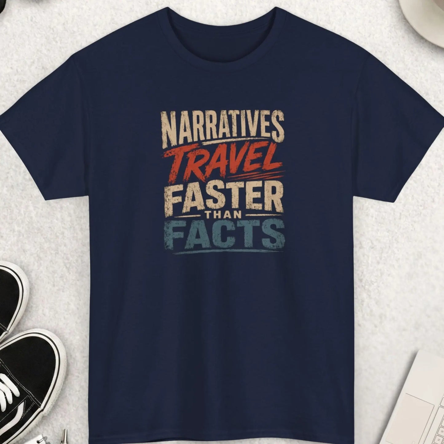 Narratives Travel Faster Than Facts vintage distressed graphic t-shirt featuring retro cream, burnt orange, and muted blue typography on a navy blue shirt with aged print texture and awareness-inspired message.