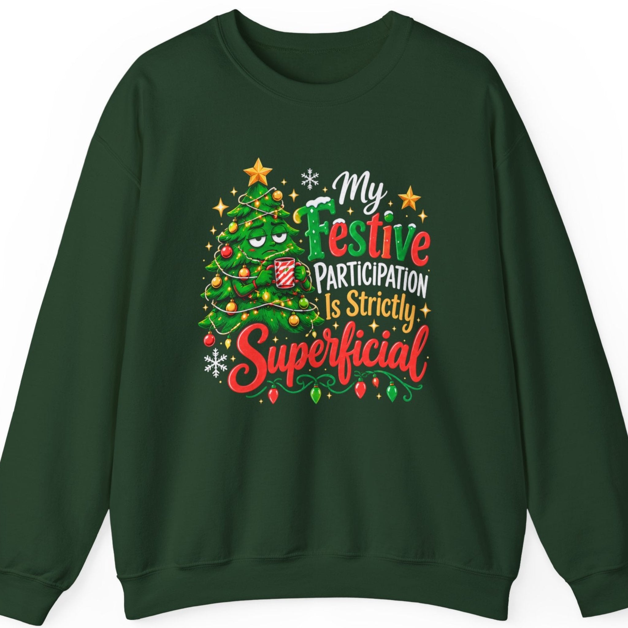 Mayhem Haus “My Festive Participation Is Strictly Superficial” forest green crewneck sweatshirt featuring a grumpy cartoon Christmas tree with an unimpressed expression, decorated with colorful ornaments and glowing Christmas lights while holding a red-and-white striped holiday mug. The design includes bold red, green, white, and gold typography, snowflakes, and festive stars.
