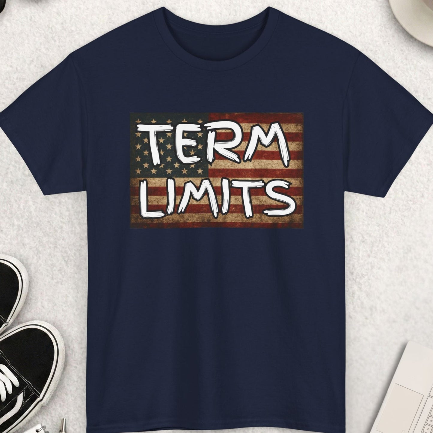 Navy blue t-shirt with 'TERM LIMITS' graphic on a light gray surface with accessories.