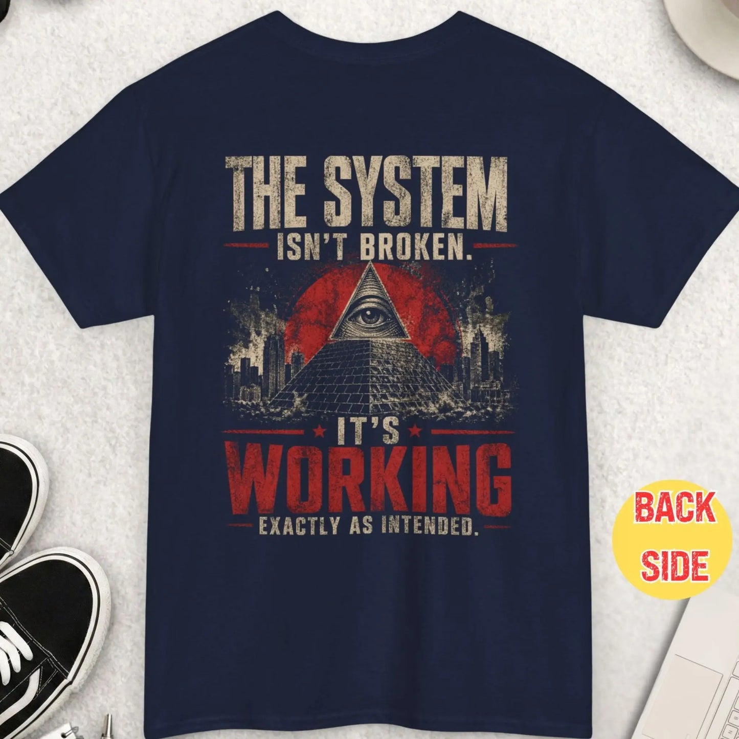 Navy blue t-shirt with bold symbolic design showing pyramid and eye with quote about the system working as intended in distressed style