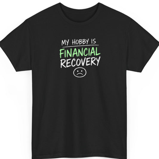 Mayhem Haus "My Hobby Is Financial Recovery" graphic t-shirt on a black shirt featuring distressed white and green typography with a minimalist sad face illustration in a clean stacked design.