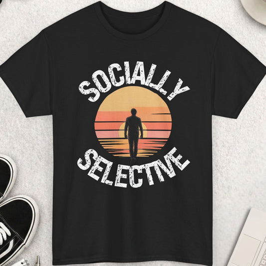 Black t-shirt with 'Socially Selective' design on a light gray surface with shoes, sunglasses, and coffee.