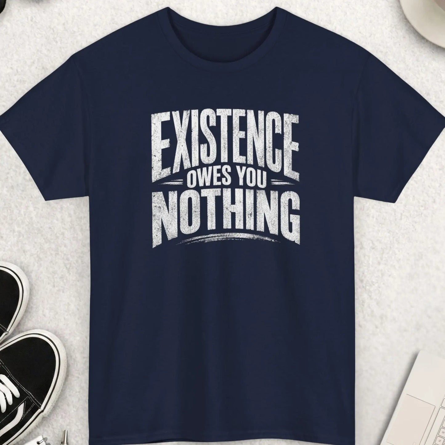Navy blue t-shirt with distressed white text stating “Existence Owes You Nothing” in a clean, bold typography layout.