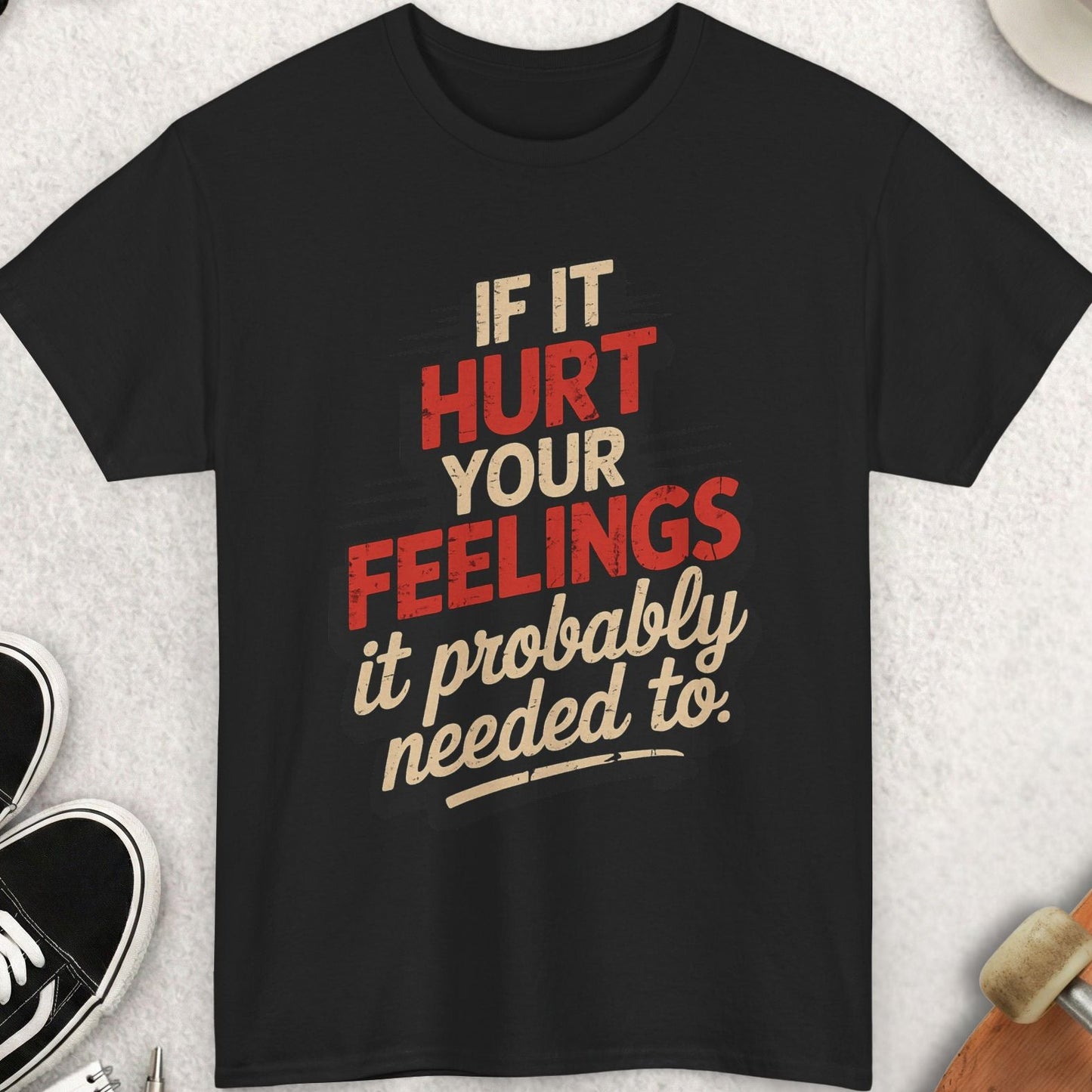 Black t-shirt with humorous text design on a light gray surface with accessories.
