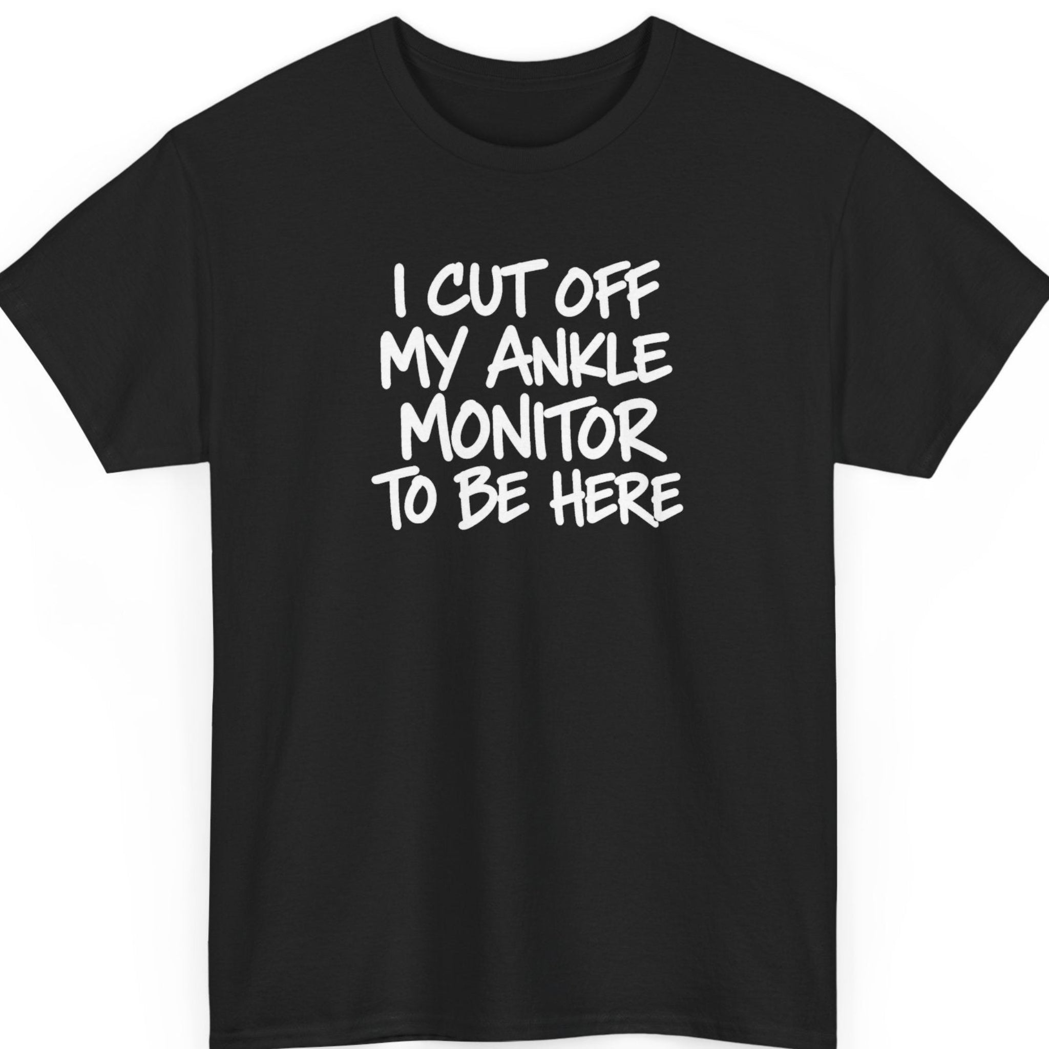 Mayhem Haus “I Cut Off My Ankle Monitor To Be Here” black t-shirt featuring bold white hand-painted brush lettering arranged in four stacked lines, creating a sarcastic, rebellious statement design.