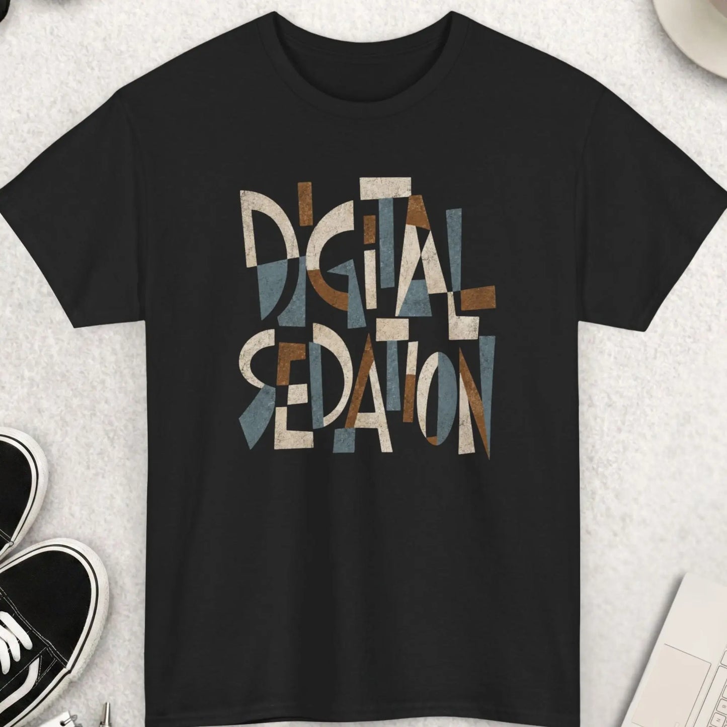 Black t-shirt featuring abstract Cubism-style typography reading “Digital Sedation” in distressed earth-tone geometric lettering.