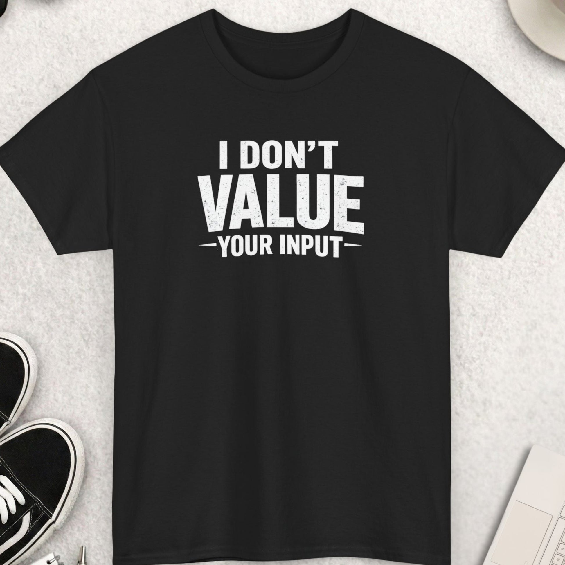 Black t-shirt with 'I Don't Value Your Input' text on a light gray surface with shoes, coffee, and accessories.