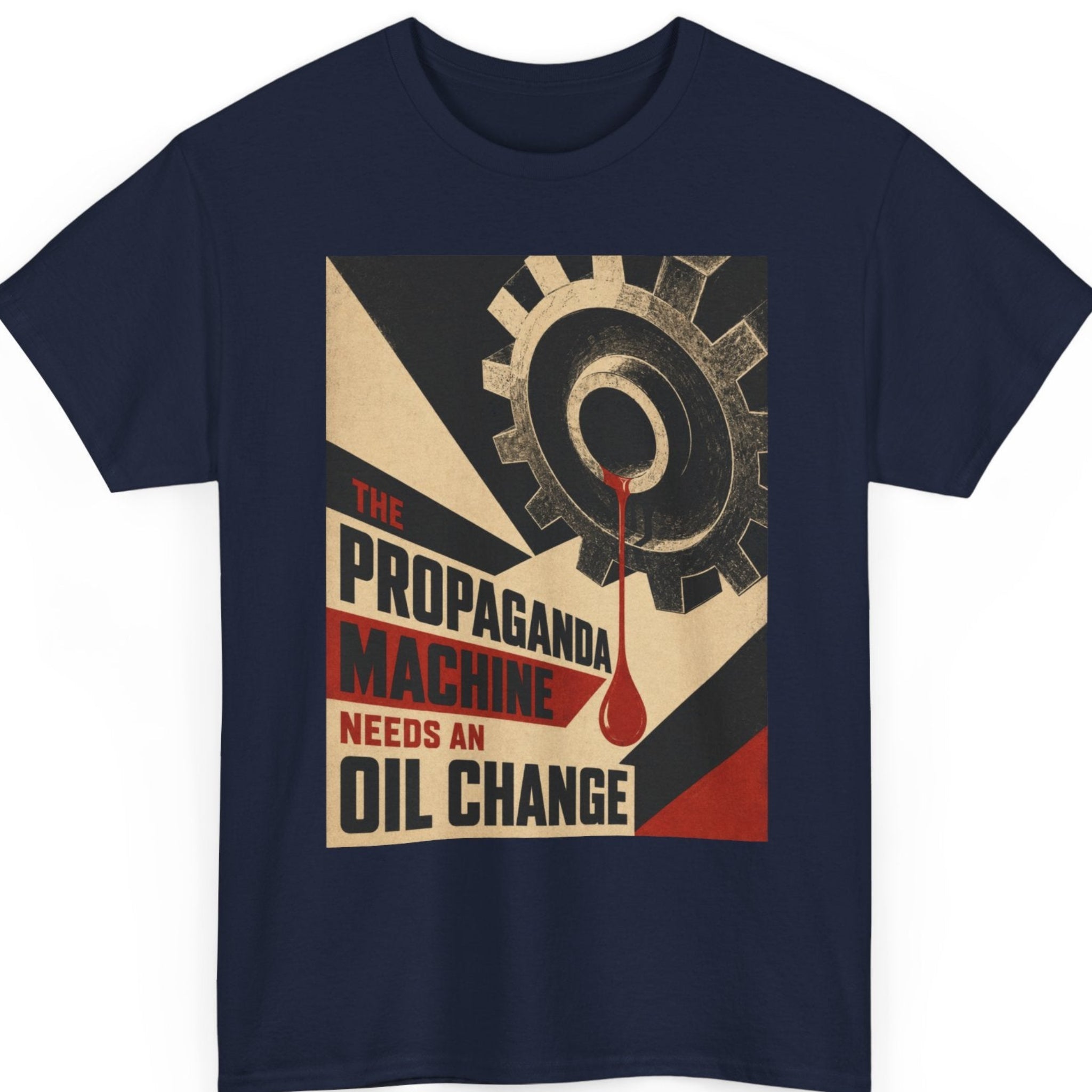 Mayhem Haus political satire graphic tee on a navy blue shirt featuring a weathered industrial gear with a red oil drip and bold propaganda-style typography that reads "The Propaganda Machine Needs An Oil Change."