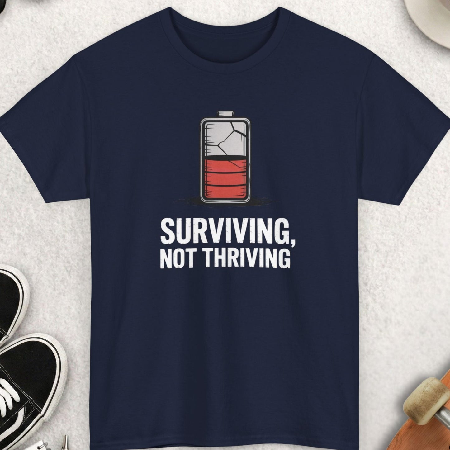 Navy blue t-shirt with motivational graphic and text on a light gray surface with accessories.