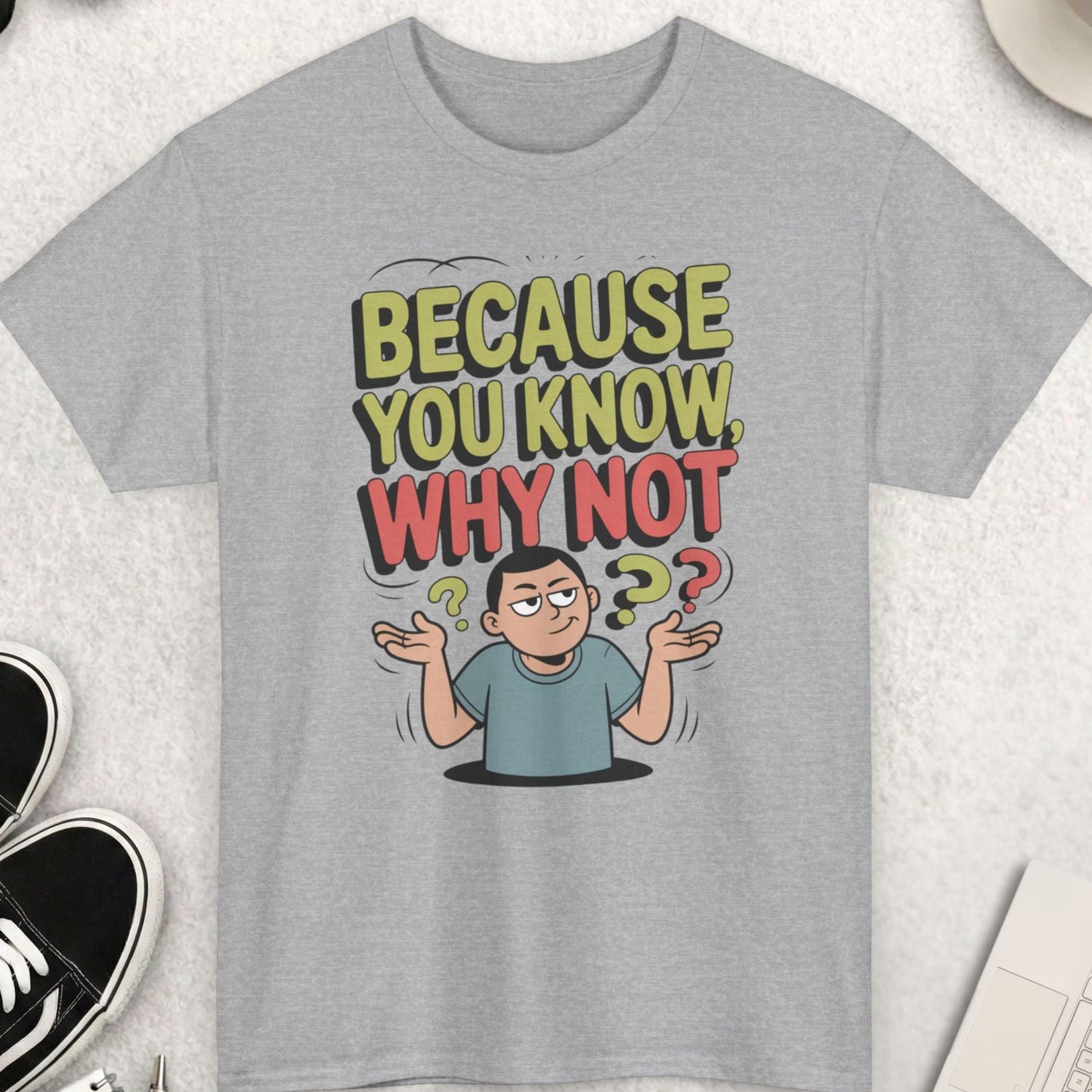 Gray t-shirt with a graphic design and text on a light gray surface with accessories.