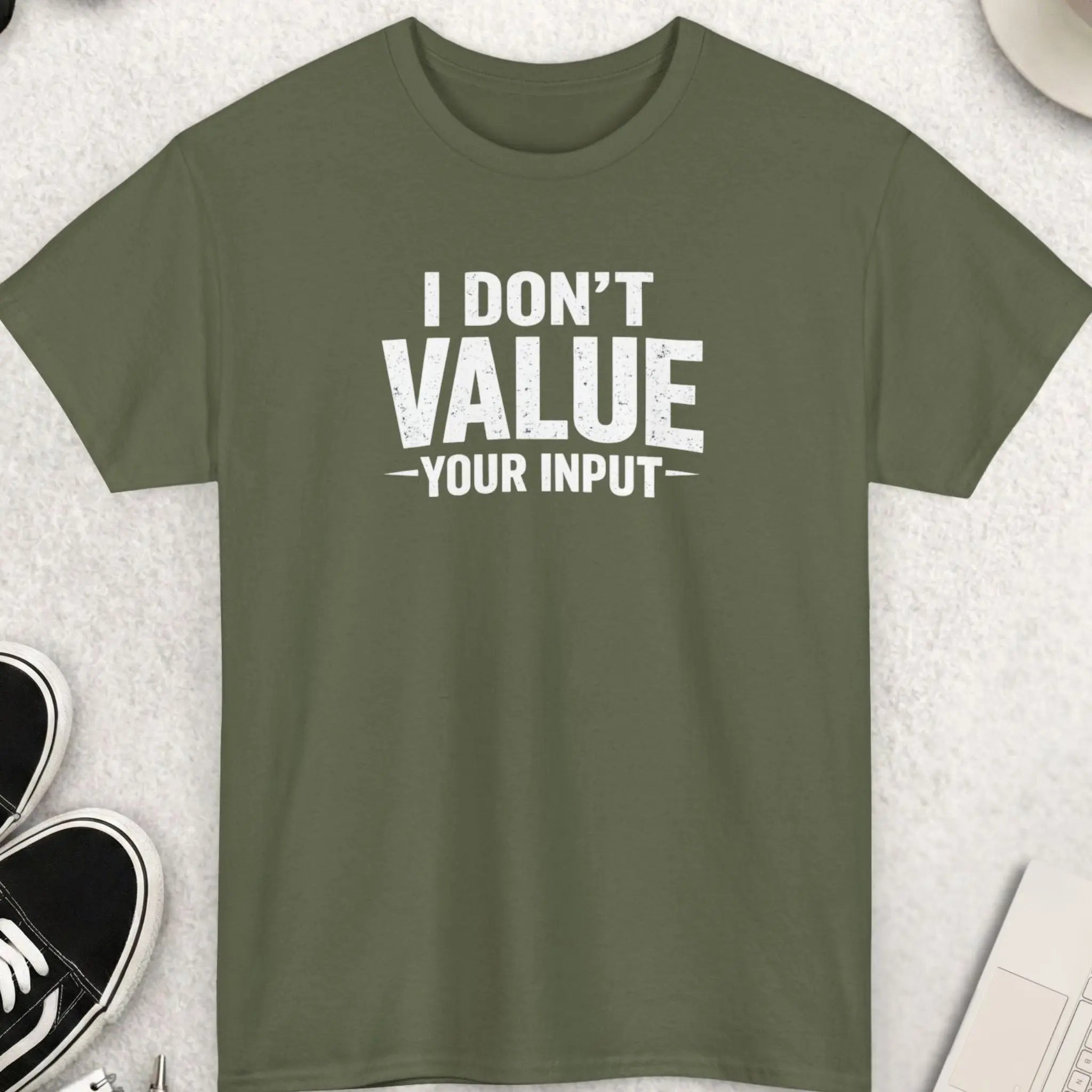 Green t-shirt with 'I Don't Value Your Input' text on a light gray surface with shoes, sunglasses, and coffee.