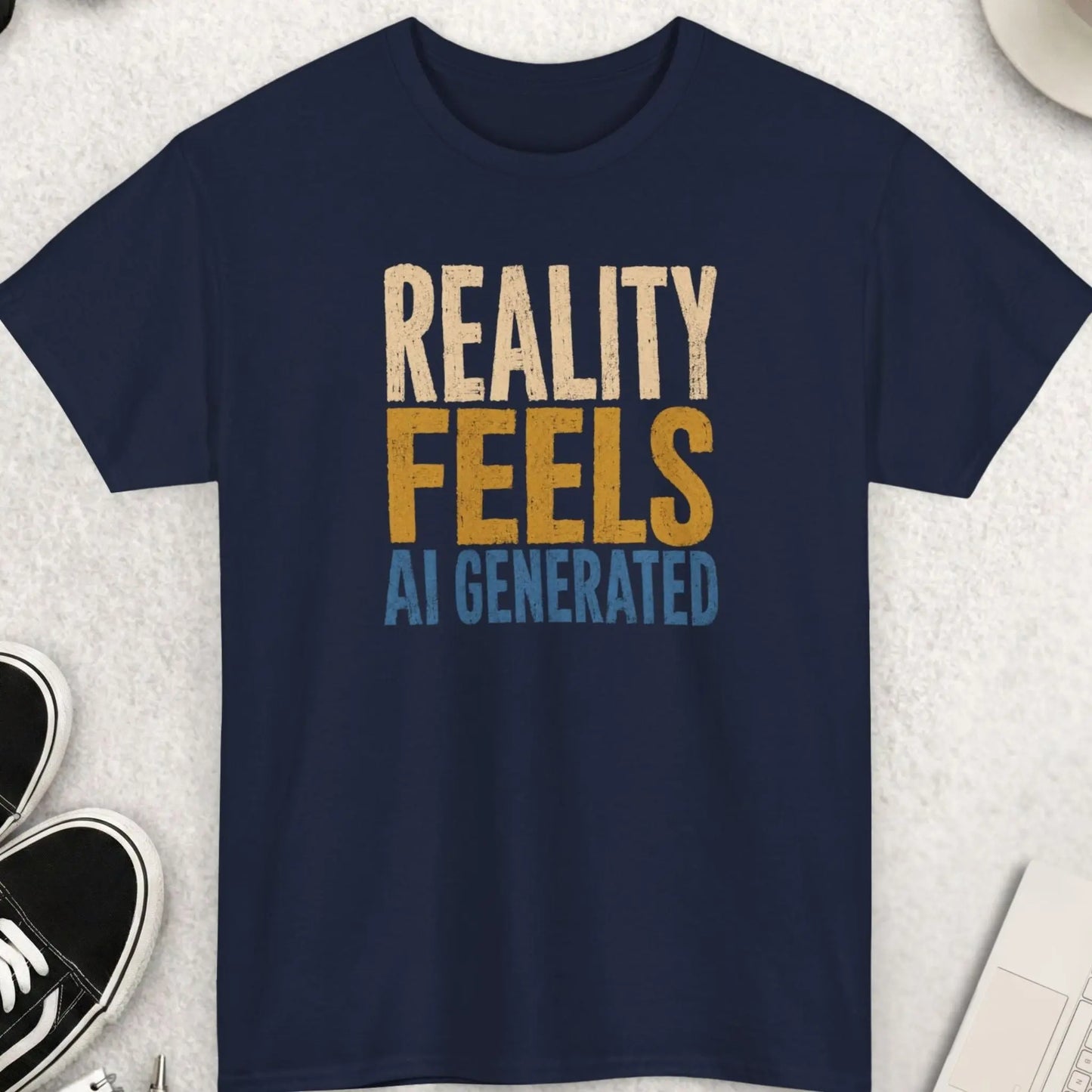 Vintage distressed statement tee featuring the phrase “Reality Feels AI Generated” in oversized cream, gold, and dusty blue typography on a navy blue shirt with existential internet culture vibe.