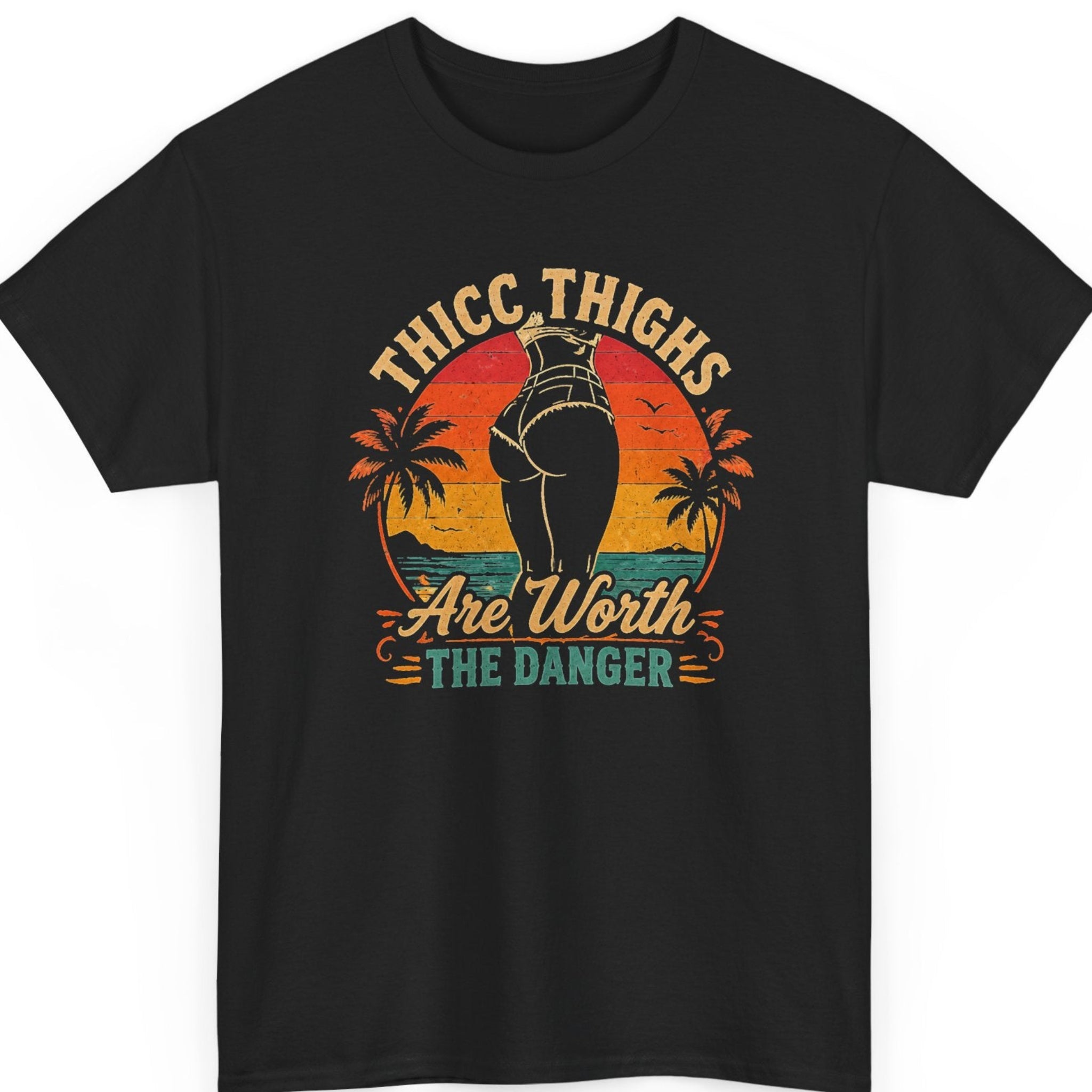 Mayhem Haus funny retro t-shirt on a black shirt featuring the phrase “Thicc Thighs Are Worth the Danger” alongside a vintage sunset scene with palm trees, an ocean backdrop, and a curvy silhouette in distressed artwork.