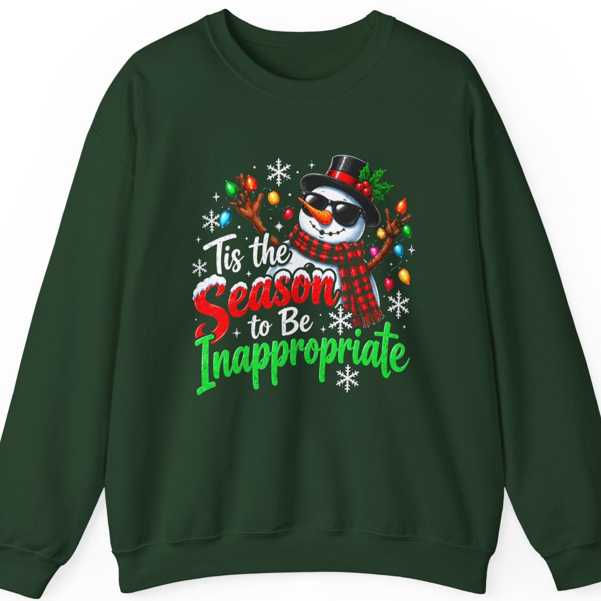 Mayhem Haus “Tis the Season to Be Inappropriate” forest green sweatshirt featuring a mischievous Christmas snowman wearing black sunglasses, a holly-decorated black top hat, and a red plaid scarf. The snowman raises its branch arms wrapped in colorful Christmas lights, surrounded by snowflakes and bold red, green, and white festive lettering.