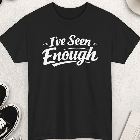 Black t-shirt with 'I've Seen Enough' text on a light gray surface with accessories.
