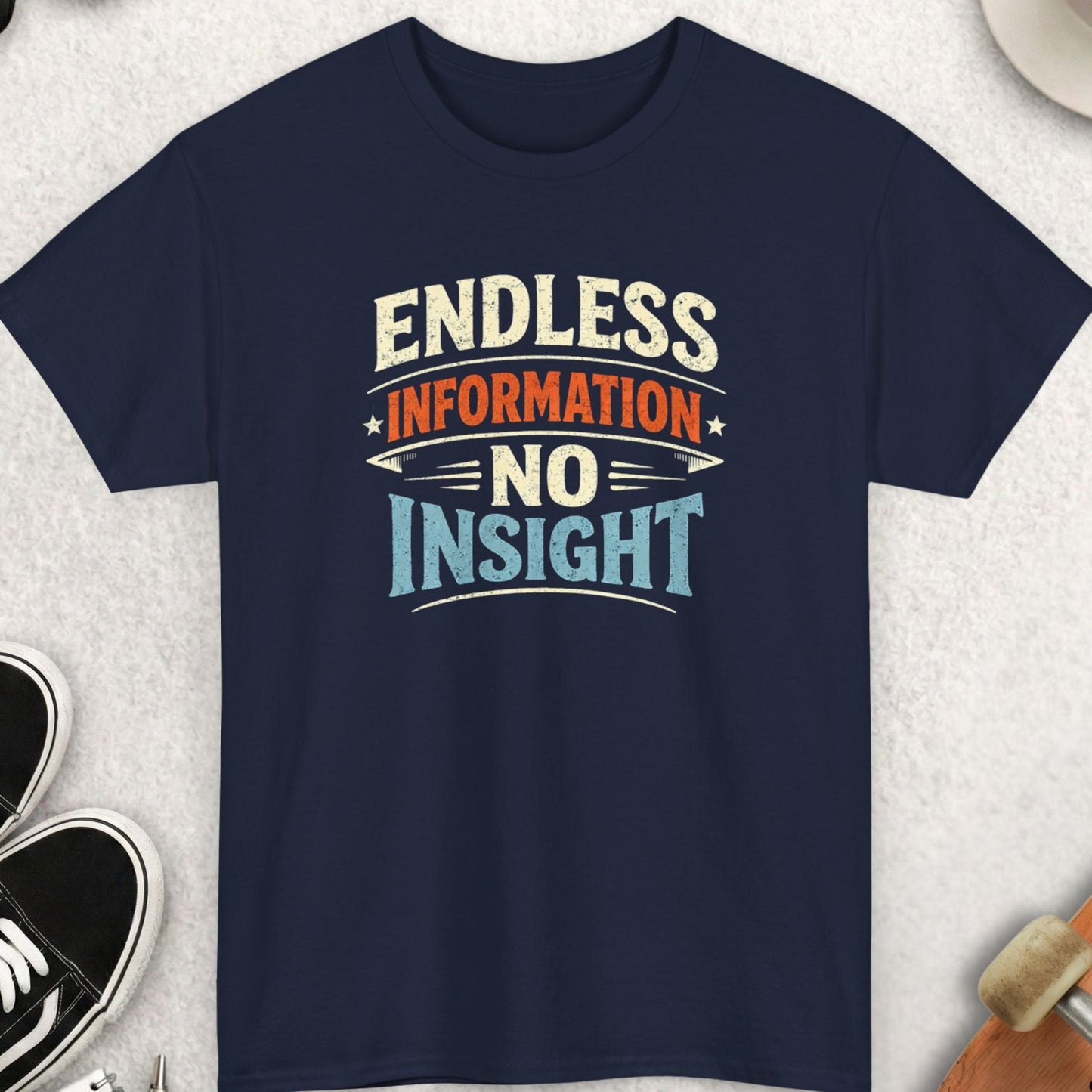 Navy blue t-shirt with 'Endless Information No Insight' text on a light gray surface with accessories.