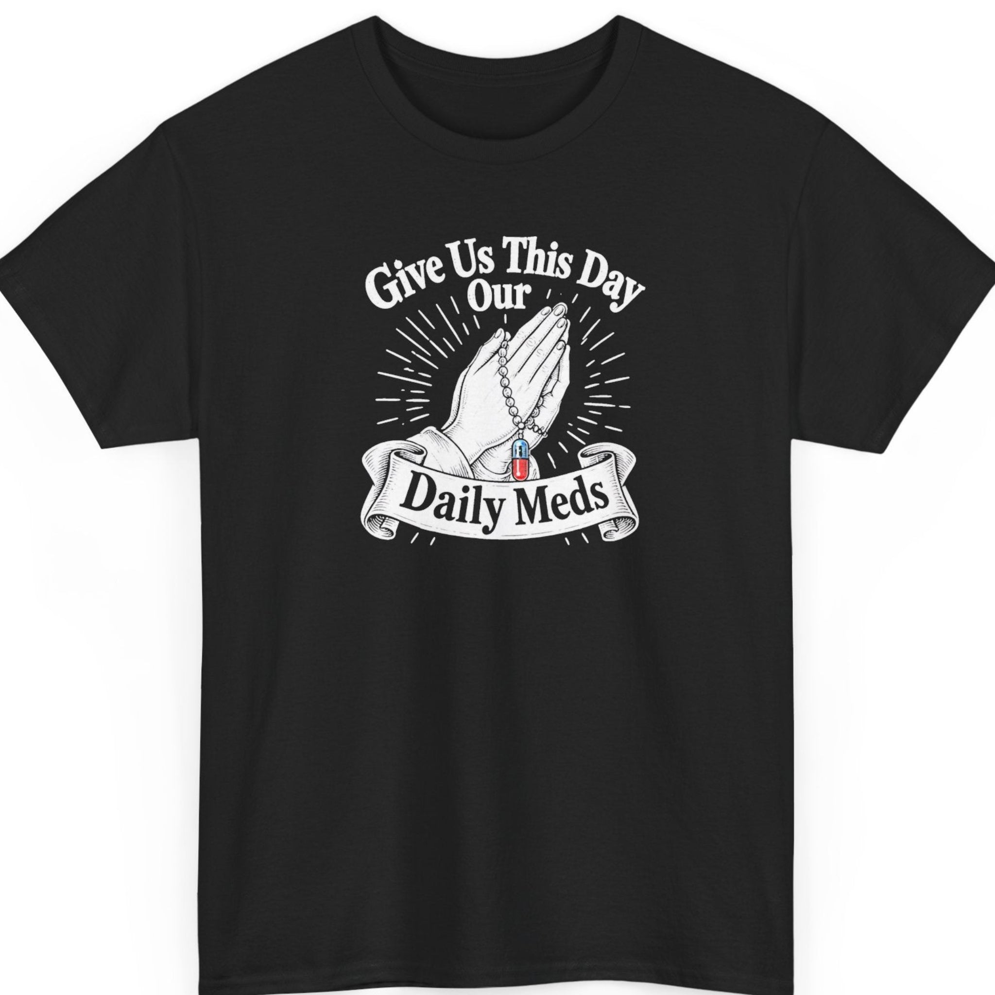 Mayhem Haus “Give Us This Day Our Daily Meds” black t-shirt featuring vintage white praying hands holding a rosary with a red and blue prescription pill, radiating lines, and a decorative ribbon banner.