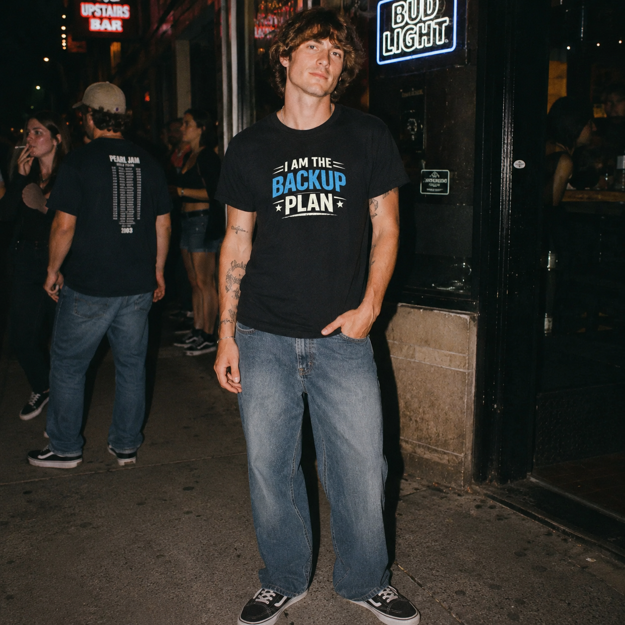 Mayhem Haus I Am The Backup Plan T-Shirt worn by a man on a street at night