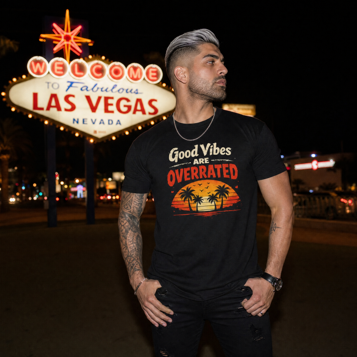 Mayhem Haus Good Vibes Are Overrated T-Shirt on a man in front of the Welcome to Las Vegas sign