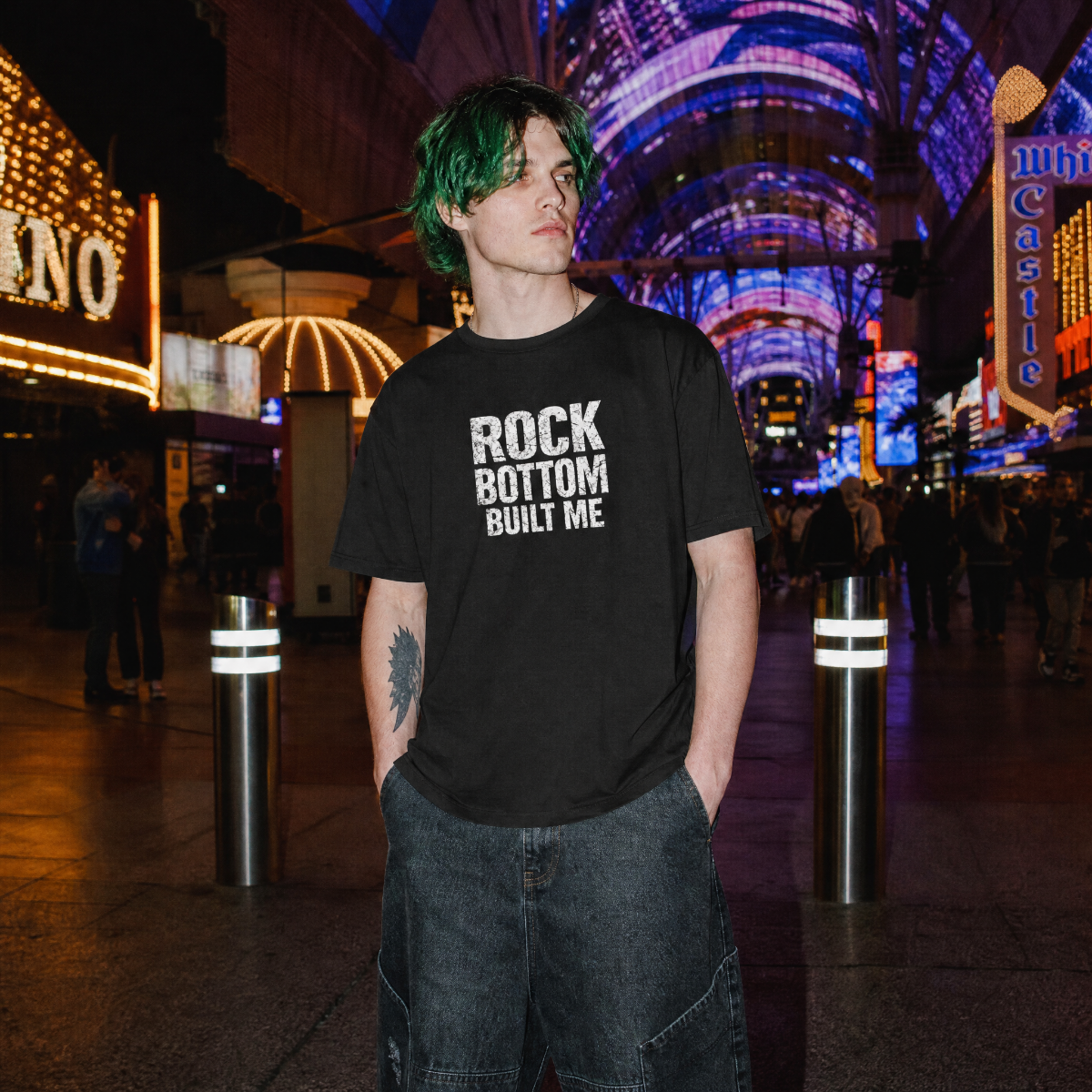 Mayhem Haus Rock Bottom Built Me T-Shirt on a person with green hair at night