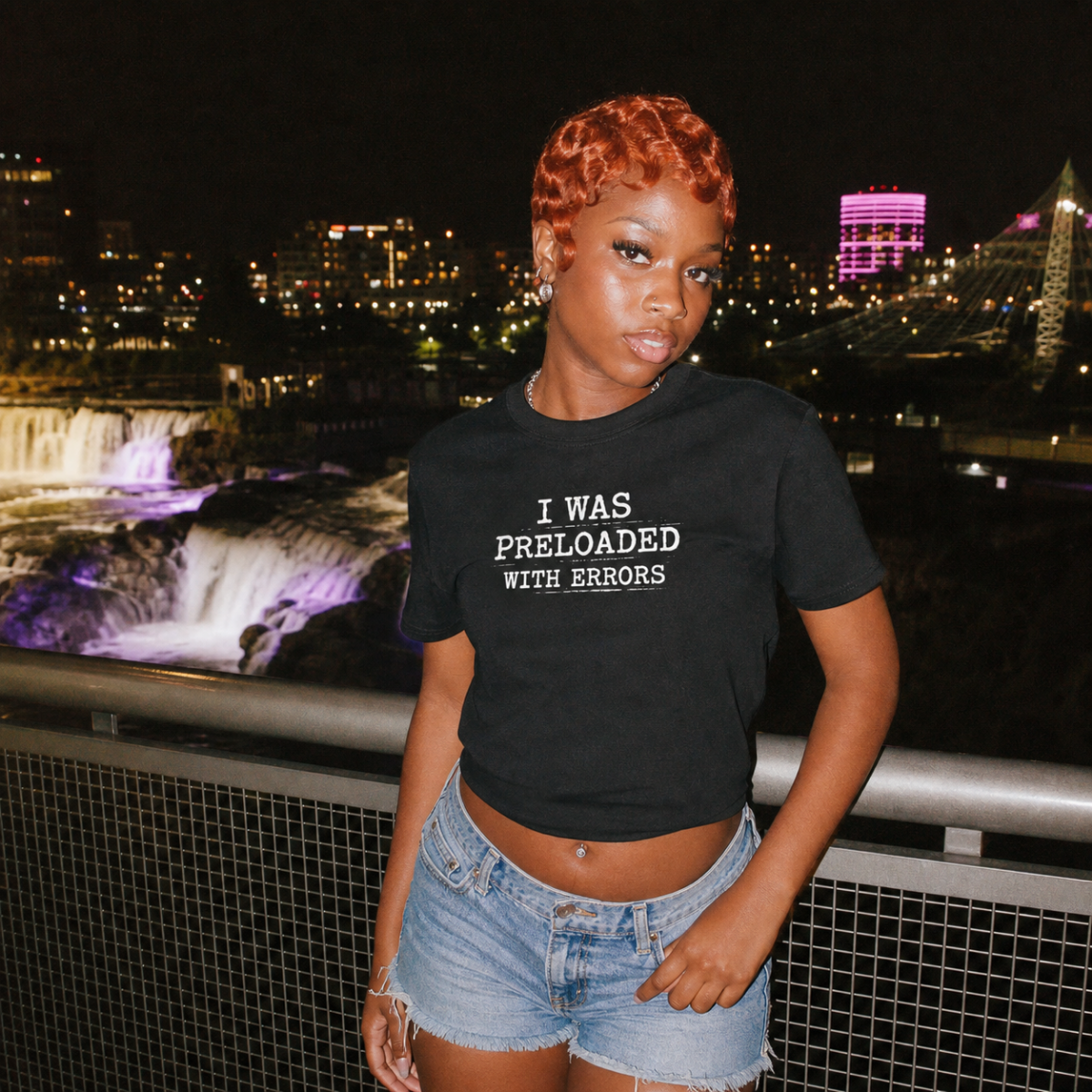 Mayhem Haus I Was Preloaded With Errors T-Shirt on a person with a city and waterfall background