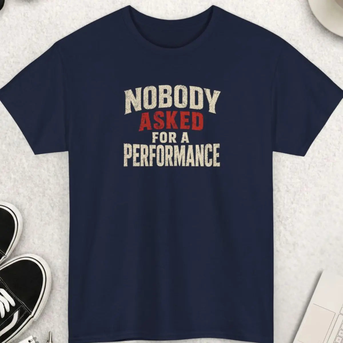 Navy blue t-shirt with distressed typography displaying the phrase “Nobody Asked For A Performance” in bold white and red lettering with a worn vintage aesthetic.